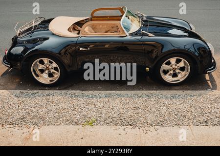 profile view of parked vintage black Porsche Convertible Stock Photo