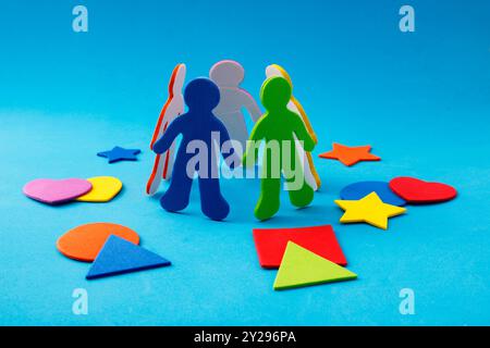 Colorful silhouettes of people forming a circle and surrounded by geometric rubber foam figures Stock Photo