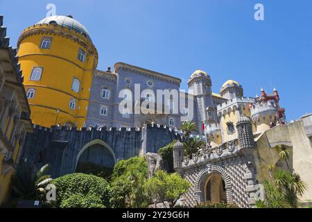 Castle with grey and yellow towers against a blue sky, surrounded by plants, Palacio Nacional da Pena, Pena National Palace, Sintra, Lisbon, World Her Stock Photo