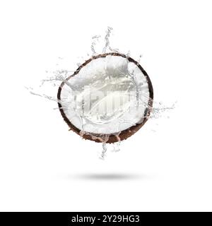 Fresh coconut water splashing from nut in air on white background Stock Photo