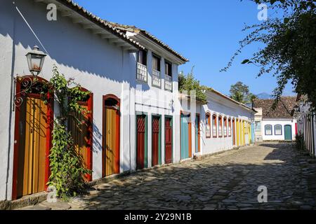 Typical cobblestone street with colorful colonial buildings in the late afternoon sun in historic town Paraty, Brazil, South America Stock Photo