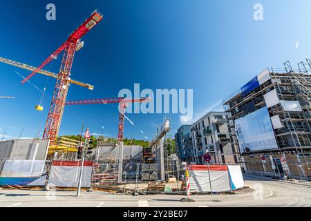 Large construction site with cranes, scaffolding and shell of unfinished buildings Stock Photo