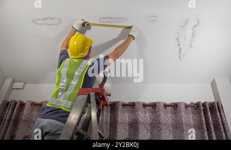 Worker fix leaking pipe in ceiling ,close-up of a stain on the ceiling. Stock Photo