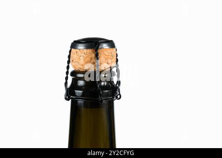 Close-up of the cork and muselet closure atop a bottle of sparkling wine unopened isolated on white background. Stock Photo