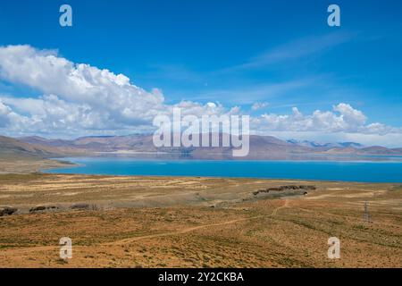 The sacred Manasarovar lake with blue transparent water in the mountains of Tibet under cloudy sky. Ngari scenery in West Tibet. Sacred place for Budd Stock Photo