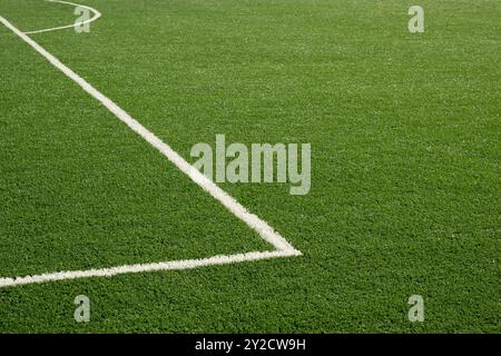 Painted white lines on soccer field with artificial green grass. Outdoors. Summer. Stock Photo