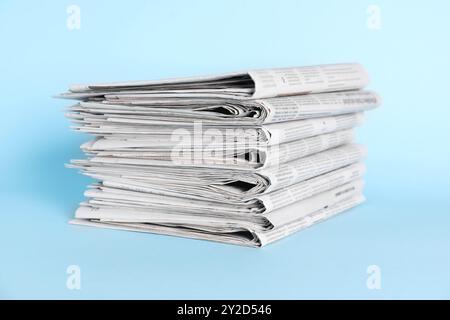 Stack of newspapers on light blue background Stock Photo