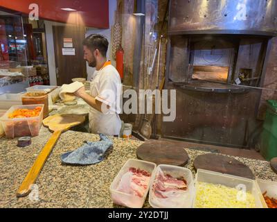 A pizza chef prepares a pizza in a restaurant in San MIguel de Tucuman, Argentina. Stock Photo