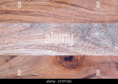 Background of red brown wood with visible grain an a knot with a horizontal lighter strip of wood Stock Photo