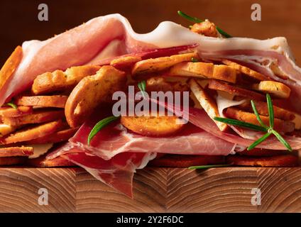 Prosciutto and bruschetta with rosemary. Macro shot. Concept of traditional Italian kitchen. Stock Photo