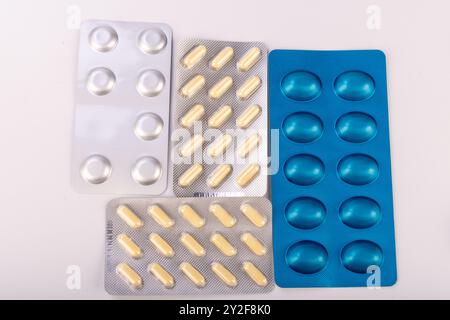 A collection of pills in a blister pack with vibrant colors, displayed on a white background, illustrating diverse pharmaceutical options Stock Photo