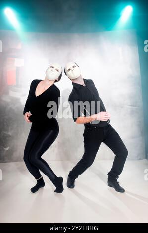 Digitally enhanced image of Masked actors in a physical theatre with a stage and lighting background Stock Photo