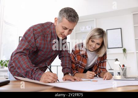 Architects making engineering drawing at wooden table in office, low angle view Stock Photo