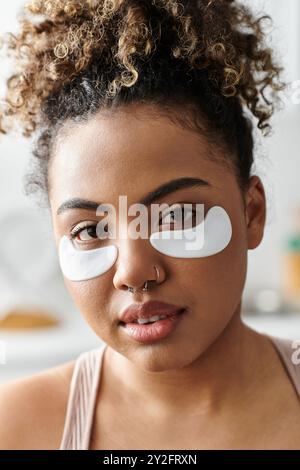 Relaxing at home, a young woman indulges in a soothing self care ritual. Stock Photo