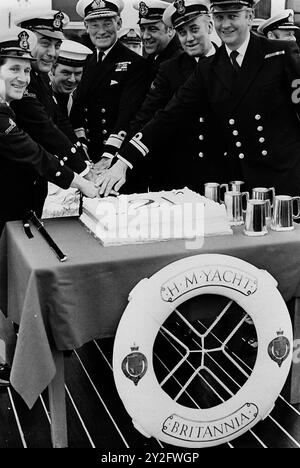 AJAXNETPHOTO. 8TH JANUARY, 1975. PORTSMOUTH, ENGLAND. - 21ST BIRTHDAY - ROYAL YACHT BRITANNIA IS 21 YEARS OLD; HAS STEAMED EQUIVALENT OF 30 TIMES AROUND THE WORLD. TO MARK THE OCCASION, REAR ADMIRAL RICHARD TROWBRIDGE (4TH FROM LEFT), FLAG OFFCIER ROYAL YACHTS, PRESIDED OVER CUTTNG OF SPECIALLY BAKED CAKE HELPED BY SIX MEMBERS OF THE CREW WHO HAVE BEEN WITH BRITANNIA SINCE SHE WAS. COMMISSIONED IN JANUARY 1954.THEY WERE EACH PRESENTED WITH A PEWTER BEER MUG AFTER THE CAKE CUTTING HAD TAKEN PLACE.   PHOTO:JONATHAN EASTLAND/AJAX REF:750103 MX340 241408 30 Stock Photo