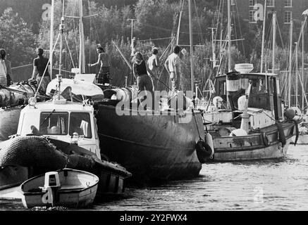 AJAXNETPHOTO. 24 AUGUST, 1978. BURSLEDON, ENGLAND. - NEW LIFE FOR AMERICA'S CUP YACHT - THE J CLASS YACHT ENDEAVOUR UNDER TOW BY THE TUG SLEDGEHAMMER TRANSITS THE UPPER REACHES OF THE HAMBLE RIVER TO HER NEW BERTH AT RIVERSIDE BOATYARD WHERE OWNERS JOHN AMOS AND GRAHAM JACK WILL BEGIN THE LONG PROCESS OF REBUILDING THE YACHT. PHOTO:JONATHAN EASTLAND/AJAXREF:2782408 1 Stock Photo