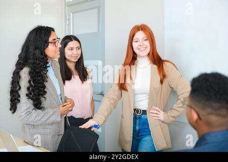 Young Female Manager Directing a Diverse Team of Young Professionals in a Lively Office Environment Stock Photo