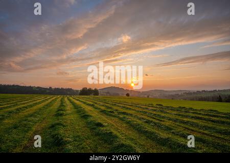 Sunset over a mountain meadow during the haying season Stock Photo