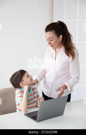Mom Teacher With Boy Schoolboy Sz Table With Online Laptop Stock Photo