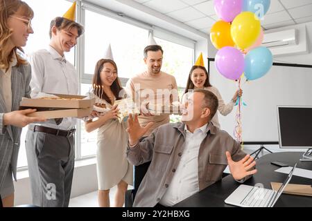 Group of business people greeting their colleague with Birthday in office Stock Photo