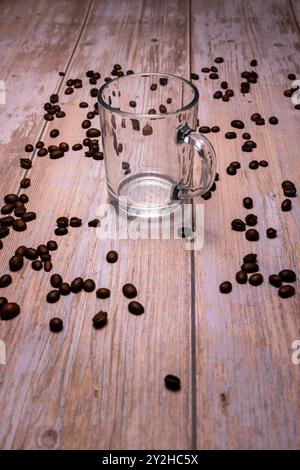 A happy ceramic mug filled with coffee next to a laptop on a rustic wooden desk, representing a cozy workspace and the joy of a coffee break work Stock Photo