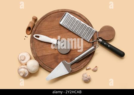 Composition with stainless steel pizza cutter, kitchen utensils, mushrooms and spices on color background Stock Photo