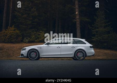 Bulgaria - 10 02 2024: Side view of a white Audi S4 quattro combi in a dark forest. Stock Photo