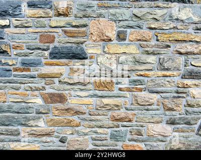 A fascinating, well-kept stone wall from 1957 made of different colored Eifel stones characterizes the Rurtalsperre in Schwammenauel, Germany, Eifel Stock Photo