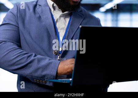 Admin in data center implementing backup solutions to protect against data loss using laptop, ensuring efficient recovery processes. Close up of worker identifying and resolving technical issues Stock Photo