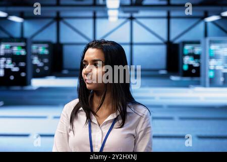 Manager overseeing server room, walking around, troubleshooting infrastructure components. Supervisor doing inspection in server hub, monitoring energy consumption across rigs Stock Photo