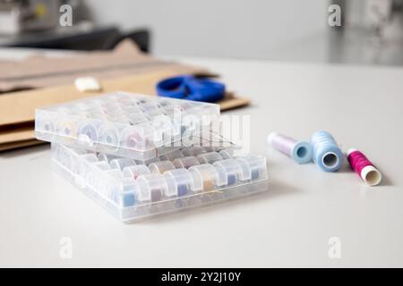 Sewing tools and supplies on seamstress desk in modern atelier studio Stock Photo