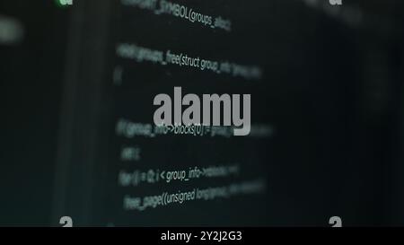 Extreme close up shot of hacking code running on computer system monitors attacking firewalls. Programming scripts shown on PC screen used by cyber criminals to breach security Stock Photo