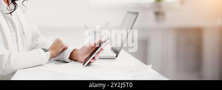 Mexican businesswoman using mobile phone at work Stock Photo