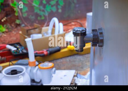 Installing water filtration system, chlorinating frame pool by maintenance service technician Stock Photo