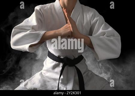 Karate fighter in smoke on black background, closeup Stock Photo