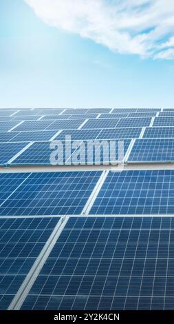 A solar panel is shown in the image, with the sun shining on it. The solar panel is blue and has a grid pattern. Concept of sustainability and environ Stock Photo