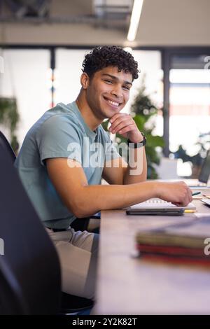 Smiling man sitting at desk, working on interior design project in office Stock Photo
