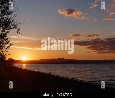Dramatic skies at sunset over Lake Bolsena and a beach near Marta, Viterbo province, Lazio region, Italy. September 10, 2024. Stock Photo