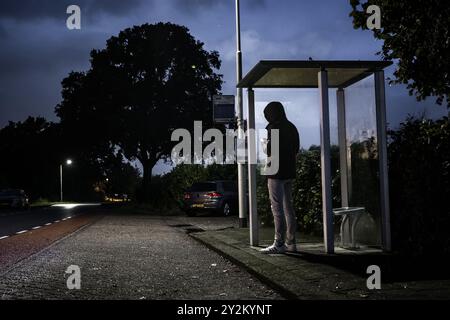 SOMEREN - A traveler at a bus stop during a strike by regional transport companies. Trade union FNV has organized several strikes. The goal is to urge the cabinet to come up with a regulation that would allow ov workers to quit heavy work earlier. ANP ROB ENGELAAR netherlands out - belgium out Stock Photo