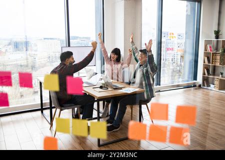 Team celebrating success in modern office setting Stock Photo