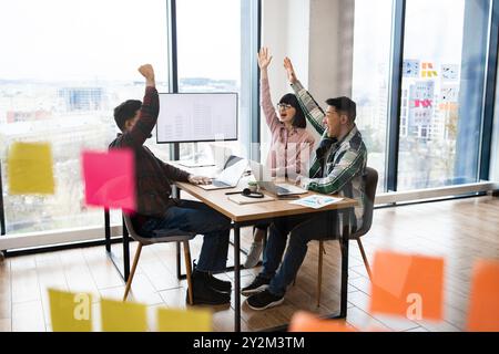 Cheerful team of architects celebrating success in office meeting Stock Photo