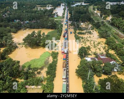 Aerial photography of buses and trucks on a flooded highway in Feni, Chittagong, Bangladesh. The flooding was caused by heavy monsoon rains and the runoff from upstream waterways. It was the worst flooding in eastern Bangladesh for 34 years and affected 5.6 million people. Photographed on 23rd August 2024. Stock Photo