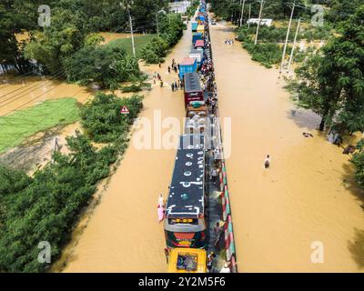Aerial photography of buses and trucks on a flooded highway in Feni, Chittagong, Bangladesh. The flooding was caused by heavy monsoon rains and the runoff from upstream waterways. It was the worst flooding in eastern Bangladesh for 34 years and affected 5.6 million people. Photographed on 23rd August 2024. Stock Photo