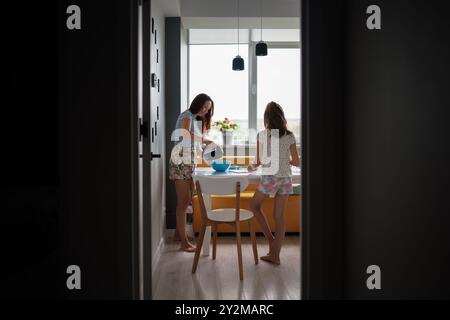 Mother and daughter baking cupcakes in a cozy home kitchen Stock Photo