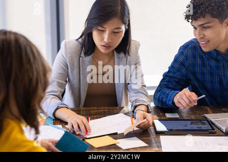 At office, Reviewing blueprints and material samples, diverse team collaborating on project Stock Photo