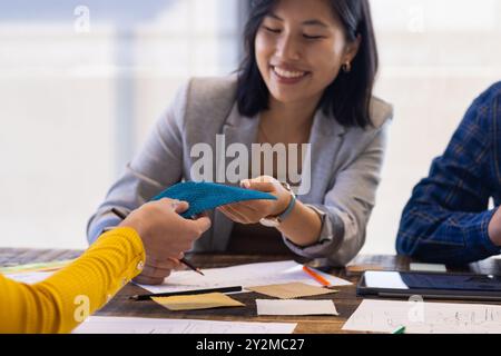 At office, asian woman collaborating on interior design project with colleague Stock Photo