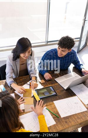 At office, Collaborating on project, diverse team using laptop, tablet, and color swatches Stock Photo