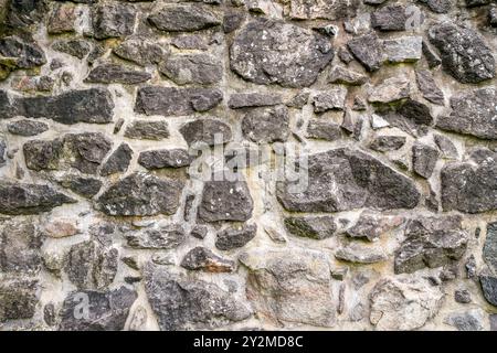 Old rustic stone wall of a medieval castle complex. Stock Photo