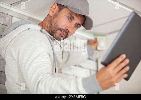 pensive young worker using pc tablet computer while working indoors Stock Photo