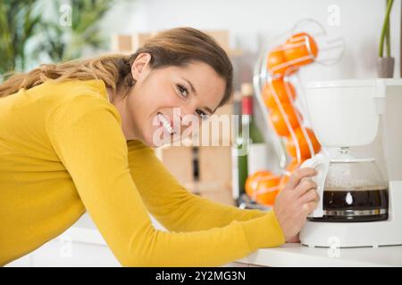 happy woman next to the oranges in the kitchen Stock Photo